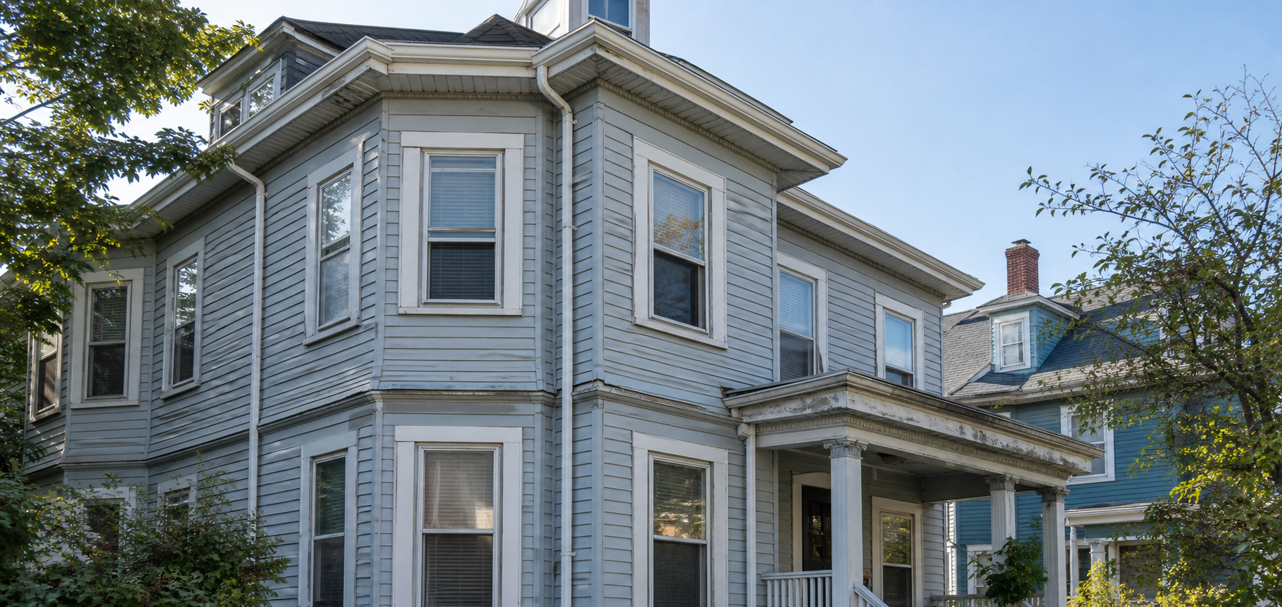 Older Somerville multifamily exterior showing trim, roofline, and porch details