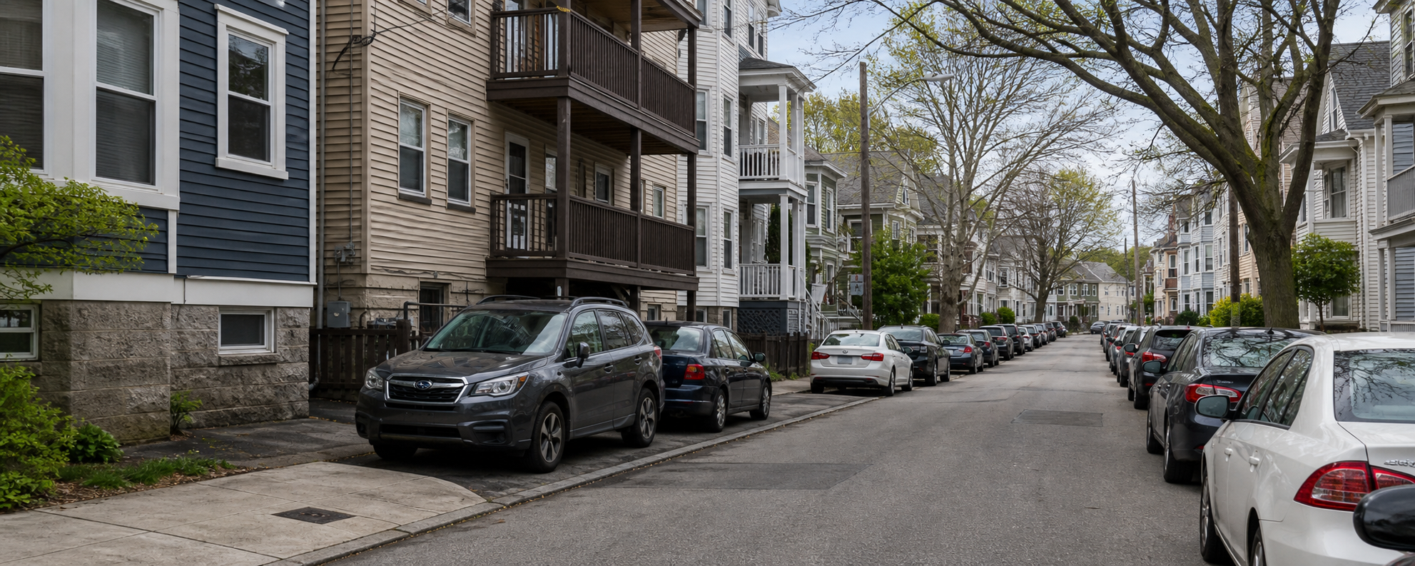 Residential Somerville street with dense curb parking near multifamily homes